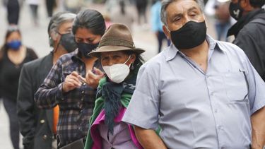 En esta fotografía de archivo del 8 de diciembre de 2020, los residentes con máscaras para frenar la propagación del nuevo coronavirus se alinean frente a un banco en Quito, Ecuador. &nbsp;