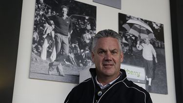 Steve John, director ejecutivo de la Monterey Peninsula Foundation y director del torneo de golf Pro-Am de Pebble Beach, posa frente a fotografías de Clint Eastwood. (AP)