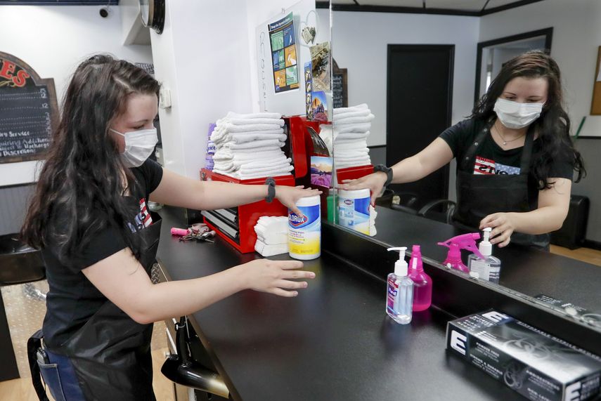 Kayla Addink acomoda art&iacute;culos de la peluquer&iacute;a en que labora en su primer d&iacute;a de regreso al trabajo en West View, Pennsylvania.