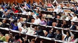 Diputados cubanos participan en una votación durante la sesión plenaria del Parlamento unicameral de la isla.