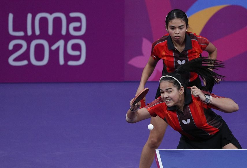 La puertorriqueña Adriana Díaz hace una devolución, delante de su compañera Melanie Díaz, en la semifinal del tenis de mesa de los Juegos Panamericanos, el lunes 5 de agosto de 2019, en Lima.