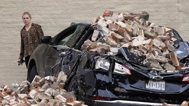 Una mujer observa los daños causados por los ladrillos caídos de la pared de un edificio tras una fuerte tormenta eléctrica el viernes 17 de mayo de 2024, en Houston.&nbsp;