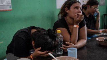 Yeneska García, migrante venezolana, llora con la cabeza entre las manos mientras come en el albergue Oasis de Paz del Espíritu Santo Amparito en Villahermosa, México.