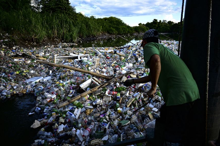 Un empleado de la ONG Marea Verde trabaja en la gigantesca máquina hidráulica y solar llamada Wanda que recoge basura del río Juan Díaz en la ciudad de Panamá el 1 de octubre de 2024. En dos años, una gigantesca máquina hidráulica ha evitado que 256 toneladas de basura, principalmente botellas de plástico, terminen en los manglares de la capital panameña.&nbsp;