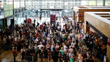 Pasajeros hacen fila para facturar en la Terminal 1 del Aeropuerto Willy-Brandt de Berlín-Brandeburgo (BER) en Schoenefeld, al sureste de Berlín, el 20 de septiembre de 2025, después de que importantes aeropuertos europeos se vieran afectados por una interrupción cibernética que afectó a los sistemas automatizados de facturación y entrega de equipaje, causando retrasos. Al menos tres aeropuertos europeos con mucha actividad informaron sobre interrupciones y advirtieron sobre retrasos y cancelaciones de vuelos.
