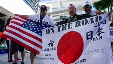Shinjiro Suzuki sostiene una bandera de Japón previo a la final del Clásico Mundial de Béisbol entre el país asiático y Estados Unidos, el martes 21 de marzo de 2023, en Miami.