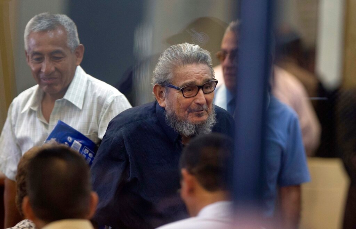 Abimael Guzman, fundador y líder del movimiento guerrillero Sendero Luminoso (al centro), mientras ingresa a la sala de un tribunal en la Base Naval de Callao, Perú. Abimael Guzman, fundador y líder del movimiento guerrillero Sendero Luminoso (al centro), mientras ingresa a la sala de un tribunal en la Base Naval de Callao, Perú.
