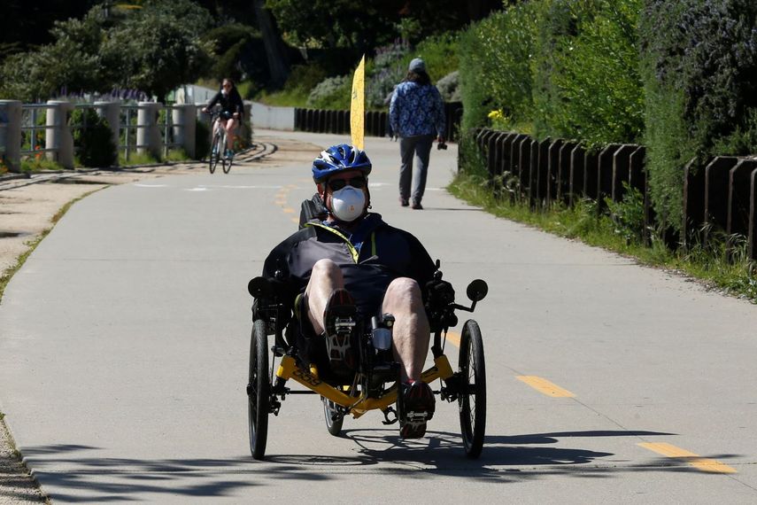 En esta imagen del martes 7 de abril de 2020, una persona con mascarilla pedalea por el sendero costero de Monterey Bay, en Monterey, California.&nbsp;