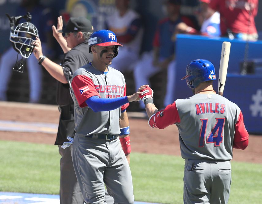 Carlos Correa (izquierda) es felicitado por Mike Avilés luego de anotar por un error en la tercera entrada.&nbsp;