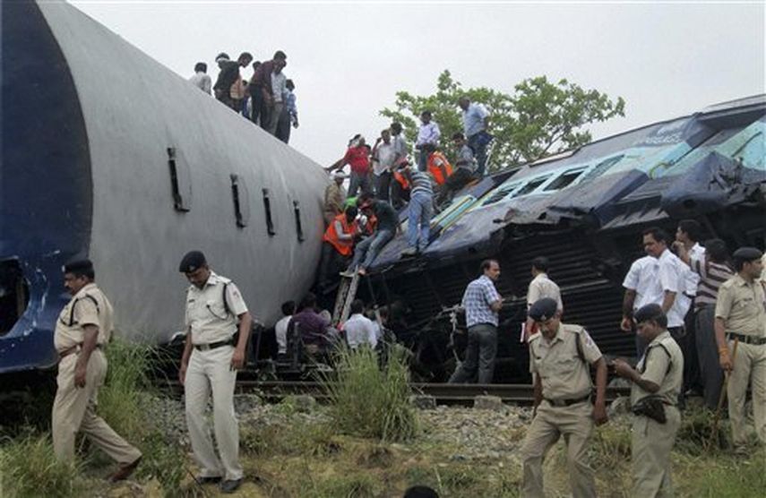 Rescatistas y agentes de seguridad junto a los restos de un choque entre el tren de pasajeros Gorakhpur Express y un tren de carga estacionado cerca de Basti, India, el lunes 26 de mayo de 2014. (Foto AP)