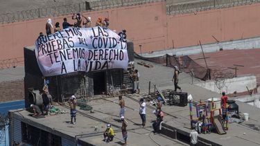Presos se re&uacute;nen en una azotea y despliegan una manta durante una protesta en el penal de Lurigancho en Lima, Per&uacute;, el martes 28 de abril de 2020.