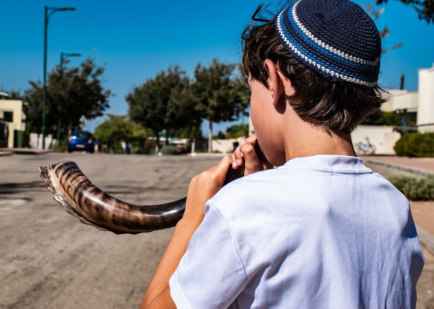 Un joven jud&iacute;o porta el kip&aacute;, mientras entona el instrumento lit&uacute;rgico shofar.