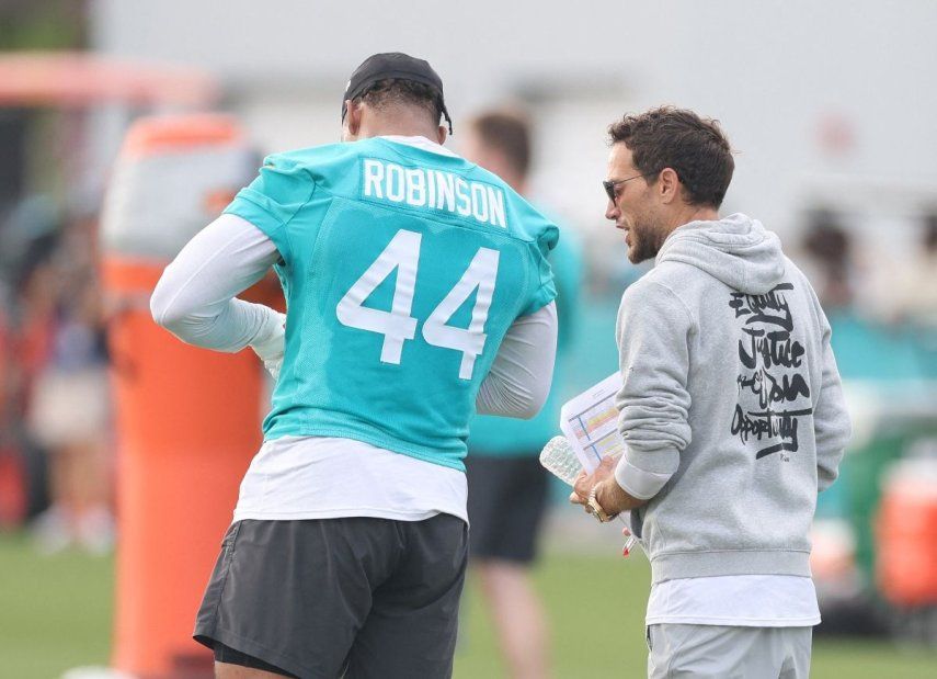 Mike McDaniel y Chop Robinson #44 de los Miami Dolphins hablan durante la práctica en el Baptist Health Training Complex el 28 de julio de 2025 en Miami Gardens, Florida.