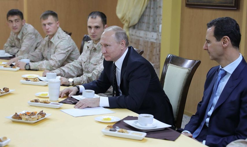 El presidente ruso, Vladimir&nbsp;Putin&nbsp;(2-dha), y su homólogo sirio, Bashar al-Assad (dcha), se reúnen con los militares de la base aérea de Hmeimim, al sudeste de Latakia, Siria.