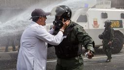 &nbsp;Un manifestante intenta hablar con un Guardia Nacional, segundos antes de ser derribado por la acción de la ballena, que le lanzó un chorro de agua.