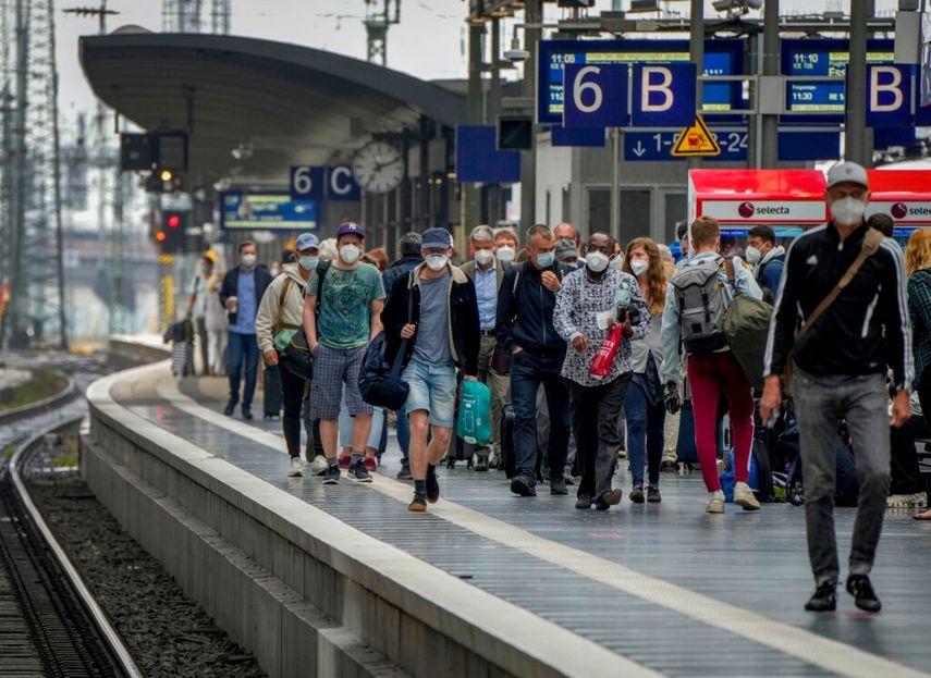 Un grupo de pasajeros con mascarillas para protegerse del coronavirus camina sobre un andén el jueves 24 de junio de 2021 en la principal estación ferroviaria de Fráncfort, Alemania.&nbsp;