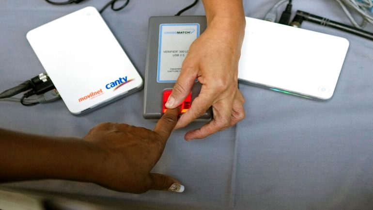 Una persona coloca su dedo para registrar su huella digital en una mesa instalada por el Consejo Nacional Electoral (CNE) para firmar a favor de la realización de un referendo revocatorio contra Nicolás Maduro.