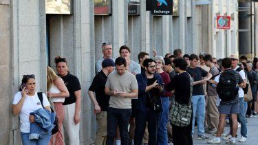 La gente hace cola para intentar retirar dinero en efectivo en un cajero automático, ya que el pago con tarjeta de crédito no está disponible debido a un corte de energía masivo en España, en Madrid, el 28 de abril de 2025.