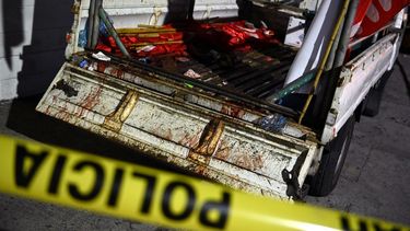 Policías custodian un camión que transportaba simpatizantes del partido político Frente Farabundo Martí (FMLN), atacado con armas de fuego cuando regresaba de la actividad política, cerca del Hospital Rosales, en San Salvador, el 31 de enero de 2021. Ataque de desconocidos en el centro de San Salvador en una caravana de militantes del FMLN dejó dos muertos y cinco heridos el domingo, informó la Fiscalía.