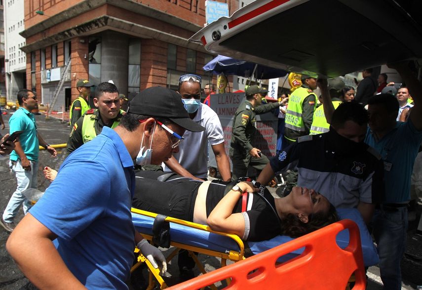 Una mujer recibe atención médica este 2 de noviembre de 2018 luego de una explosión en la sala de evidencias de una sede de la Fiscalía General de Colombia, en Cali.