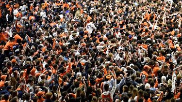 Los aficionados irrumpen en la cancha al final de un partido de baloncesto universitario en Champaign, Illinois, el domingo 6 de marzo de 2022.
