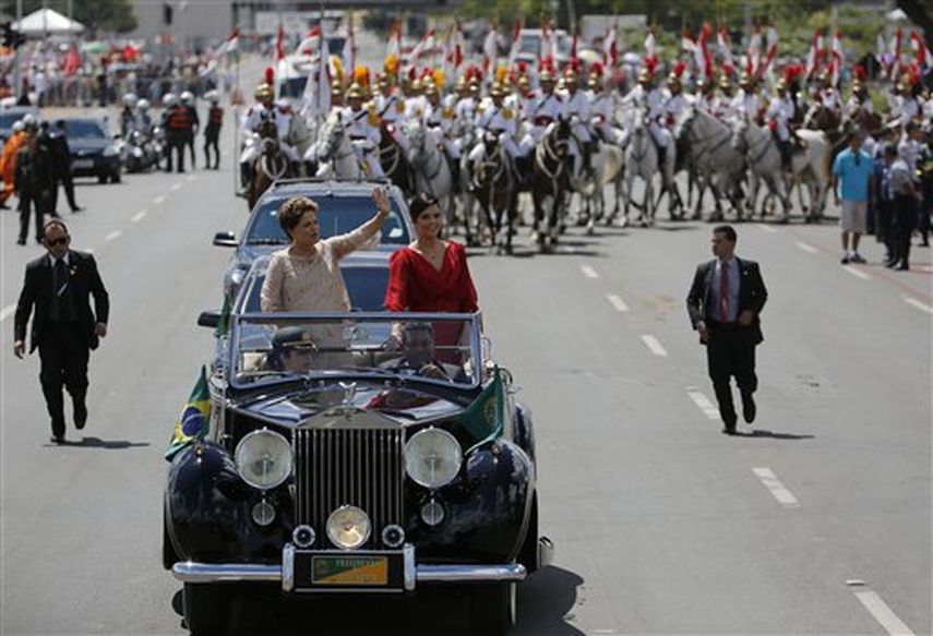 La presidenta de Brasil, Dilma Rousseff (izquierda), saluda a la multitud acompañada de su hija, Paula Rousseff Araujo, en un Rolls Royce hacia el Congreso Nacional para la ceremonia en la que prestará juramento para un segundo mandado de cuatro años,