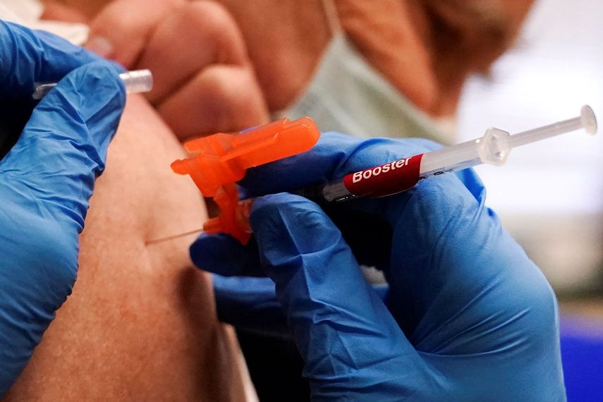 Un empleado inyecta a una persona con una dosis de refuerzo de la vacuna Moderna contra el COVID-19 en una clínica de vacunación en Lawrence, Massachusetts.