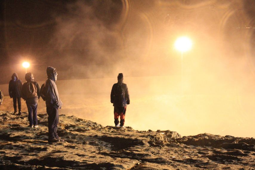 Migrantes centroamericanos esquivan el humo del gas lanzados por los guardias de la policía fronteriza estadounidense durante su intento de cruzar la frontera que limita a México con EEUU en los primeros minutos de este martes 1 de enero de 2019.