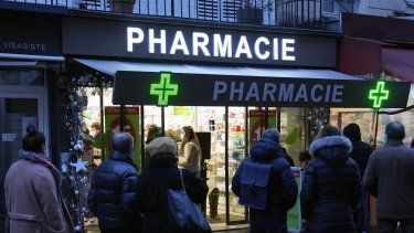 Varias personas esperan frente a una farmacia para hacerse una prueba de COVID-19 el domingo 9 de enero de 2022 en París, Francia.