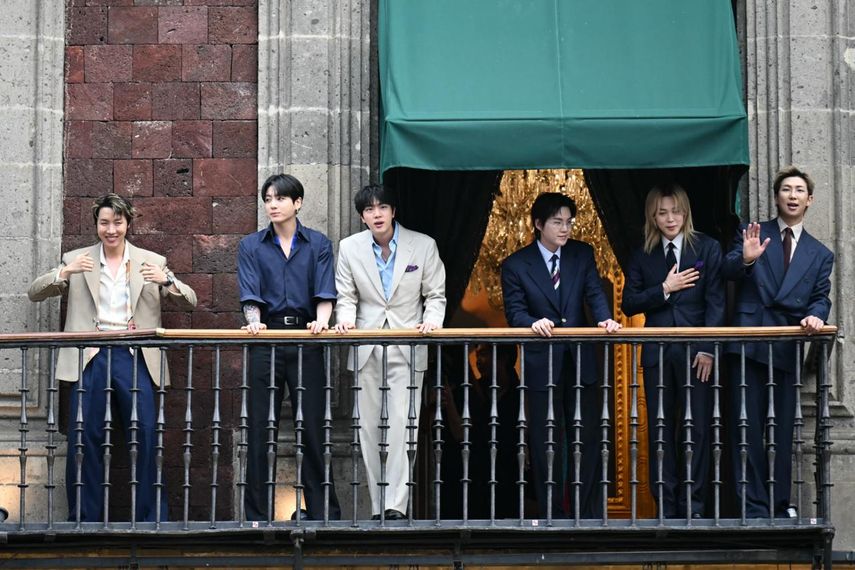 El grupo surcoreano de K-pop BTS saluda a sus fans desde el balcón del Palacio Nacional, en la Plaza del Zócalo de la Ciudad de México, el 6 de mayo de 2026.