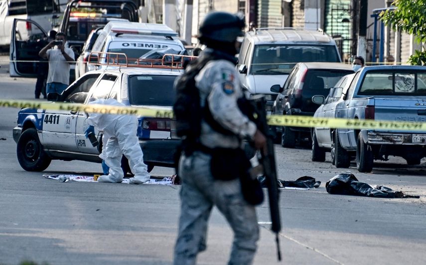 Un miembro de la Guardia Nacional asegura el área mientras personal forense trabaja en el sitio donde fueron abandonados pedazos de cuerpo humano en la ciudad portuaria turística de Acapulco, estado de Guerrero, México, el 7 de julio de 2024.