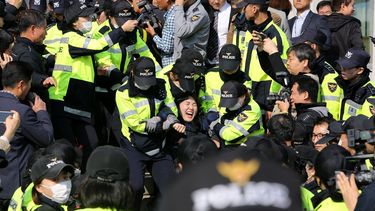 La policía detiene a estudiantes ante la Asamblea Nacional en Seúl, durante una manifestación convocada para protestar en contra de la próxima visita del presidente Donald Trump. 