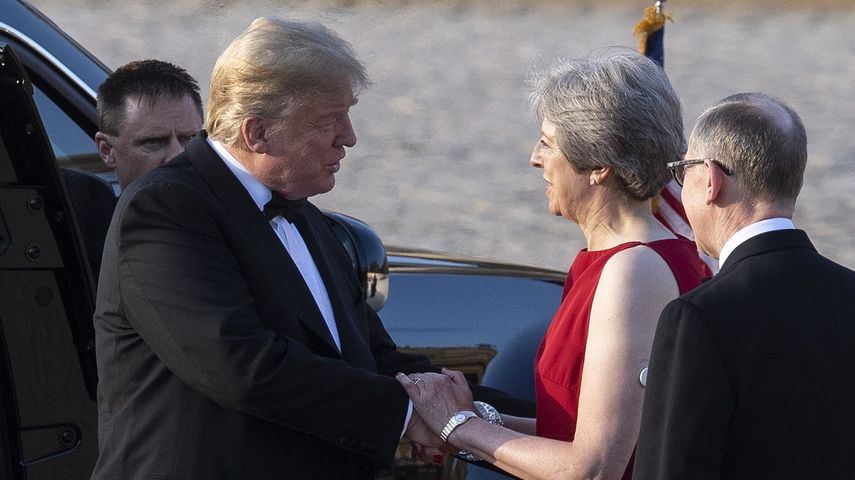 La primera ministra británica Theresa May y su esposo Philip hablan con el presidente Donald Trump.