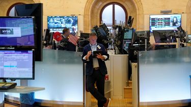 Agentes de Wall Street trabajan en el piso de remate.