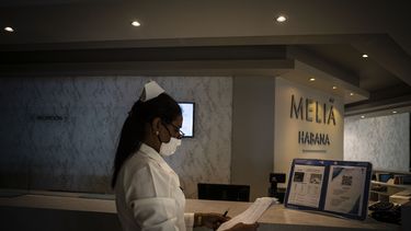Con una máscara contra la propagación del nuevo coronavirus, la enfermera Yenis Mercedes espera en la recepción del Hotel Meliá Habana la llegada de turistas a La Habana, Cuba, el jueves 11 de febrero de 2021.