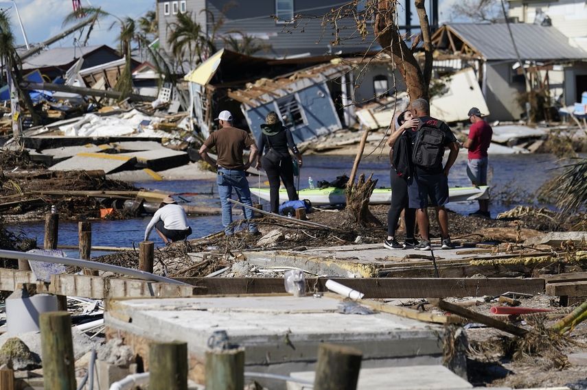 Gente de pie en el puente destruido a Pine Island mientras contemplan los daños causados por el huracán Ian en Matlacha, Florida, el domingo 2 de octubre de 2022. El único puente a la isla estaba muy dañado y sólo se podía acceder por mar o aire.&nbsp;