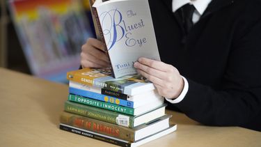 Amanda Darrow, directora los programas de educación para jóvenes y familias en el Centro de Orgullo de Utah, posa con unos libros que han sido objeto de críticas por parte de los padres, el 16 de diciembre de 2021, en Salt Lake City. La inteligencia artificial sacude el mundo de la edición.