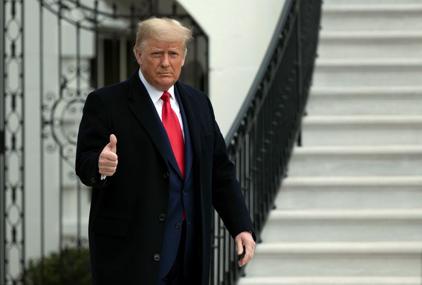 El expresidente Donald Trump saluda a periodistas.