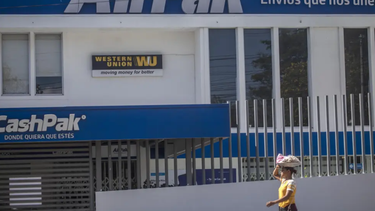 Una vendedora de dulces pasa por una rama de la Western Union en Managua, Nicaragua, el sábado 25 de febrero de 2023. Las remesas enviadas por los nicaragüenses a casa, principalmente de Estados Unidos, siguen en aumento debido a la alza de la migración.