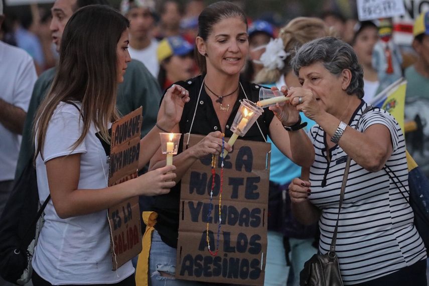 Mujeres encienden velas en honor a víctimas de la represión.&nbsp;