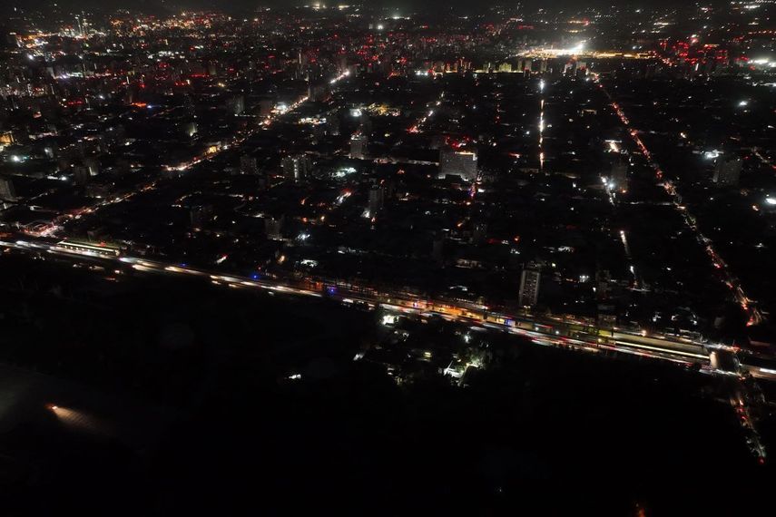 Esta vista aérea muestra la ciudad parcialmente iluminada durante un apagón en Santiago el 25 de febrero de 2025. En plena temporada de verano austral, Chile enfrenta este martes un inusual y masivo apagón debido a una supuesta falla del sistema eléctrico, que obligó a la evacuación del metro de Santiago y sumió en la confusión a la población.&nbsp;