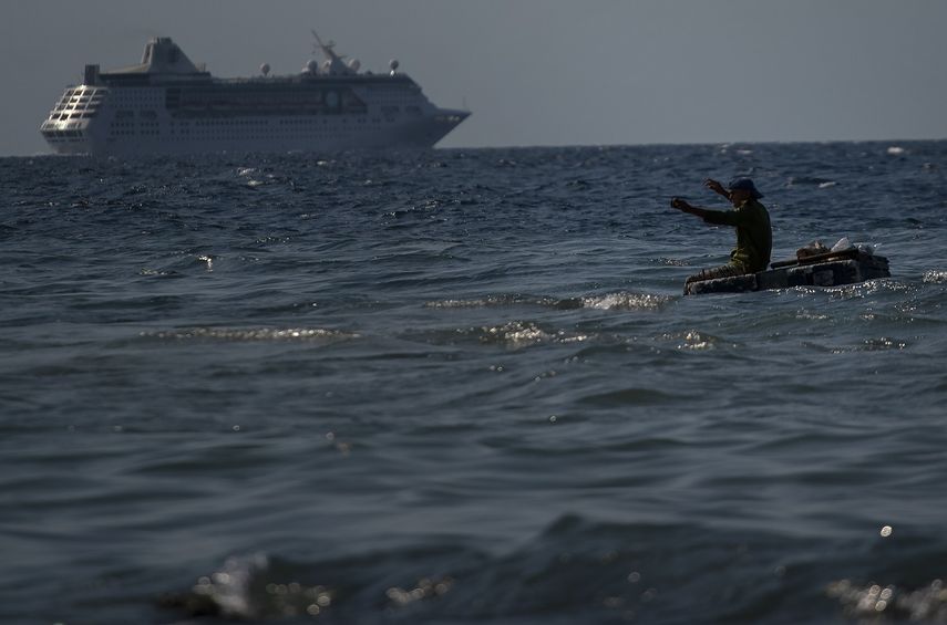 Un hombre pesca en una balsa improvisada mientras&nbsp;un crucero&nbsp;se aleja del puerto en La Habana, Cuba, el 5 de junio de 2019.