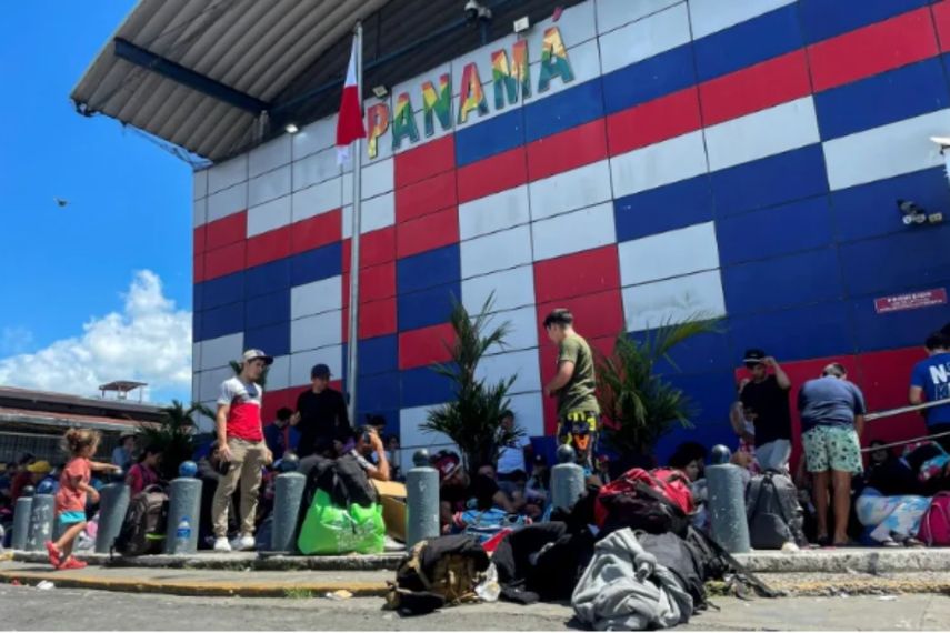 Migrantes venezolanos permanecen afuera de una oficina de inmigración mientras esperan un permiso para seguir el viaje de regreso a su país en la localidad panameña de Paso Canoas, frontera de Panamá con Costa Rica, el 11 de febrero de 2025 (Paul MONTENEGRO)&nbsp;(Paul MONTENEGRO/AFP/AFP)