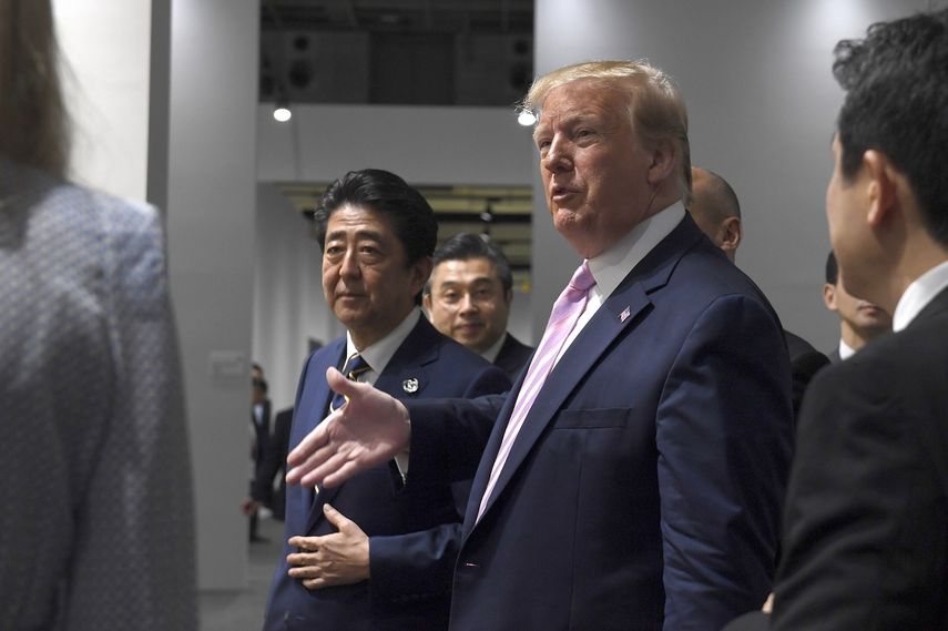 El presidente Donald Trump camina al lado del primer ministro japonés, Shinzo Abe, tras su llegada a Osaka, Japón, el viernes 28 de junio de 2019.