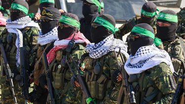 Combatientes de Hamás aseguran un área en una plaza antes de liberar a cuatro rehenes israelíes a un equipo de la Cruz Roja en la ciudad de Gaza el 25 de enero de 2025.
