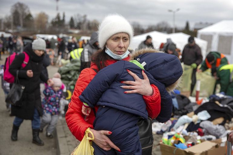 Una mujer que huyó de Ucrania carga a su hijo a su llegada al cruce fronterizo de Medyka, el lunes 28 de febrero de 2022, en Polonia.