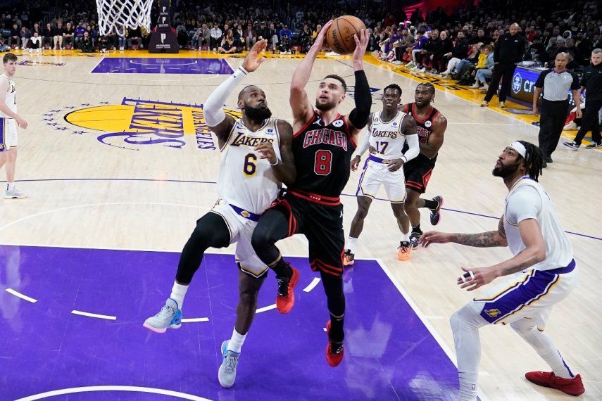 Zach LaVine (8), de los Bulls de Chicago, ataca la canasta entre LeBron James, izquierda, y Anthony Davis, de los Lakers de Los Ángeles, durante la segunda mitad del juego de baloncesto de la NBA, el domingo 26 de marzo de 2023.