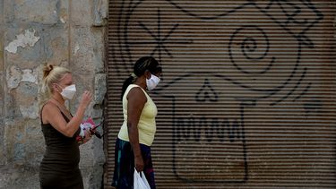 Dos mujeres usan mascarillas mientras caminan por una de las calles de La Habana, en Cuba, el 24 de marzo de 2020.