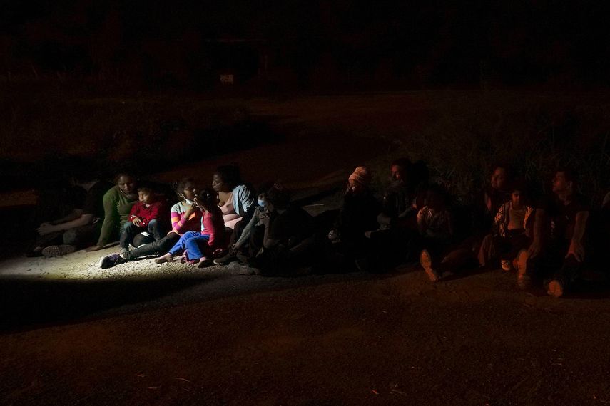 Varios migrantes, principalmente de Honduras y Nicaragua, hacen fila sentados después de entregarse al cruzar la frontera entre Estados Unidos y México, en esta fotografía de archivo del lunes 17 de mayo de 2021 en La Joya, Texas.&nbsp;