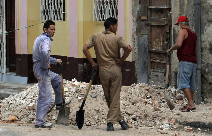 Dos hombres participan en labores de reconstrucción en una vivienda en La Habana.